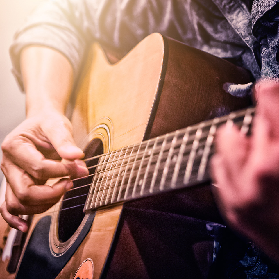 Close up of hands playing an acoustic guitar