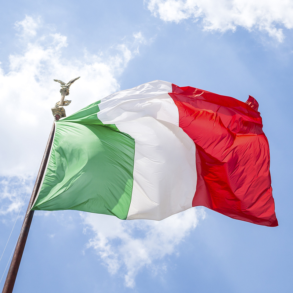 Waving Italian flag against a blue sky