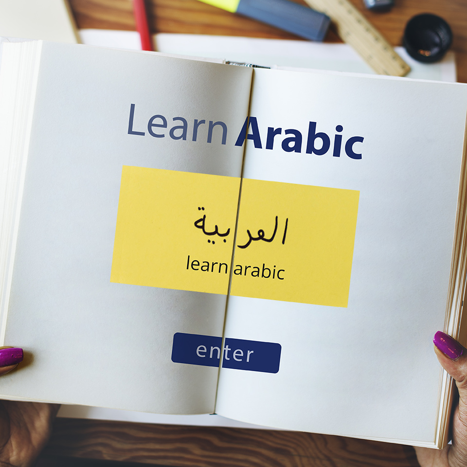 An open book with the words 'Learn Arabic' written across it in English and Arabic