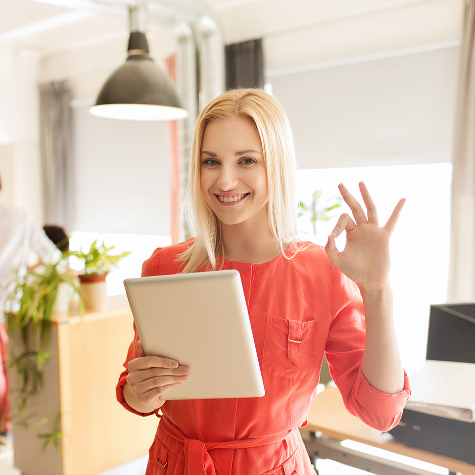 Happy office worker with tablet pc computer showing ok hand sign